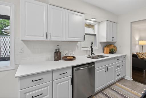 Main level: brand new kitchen with quartz counters, stainless appliances, and new LVT flooring