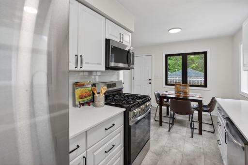 Main level: brand new kitchen with quartz counters, stainless appliances, and new LVT flooring