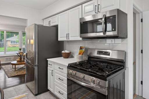 Main level: brand new kitchen with quartz counters, stainless appliances, and new LVT flooring