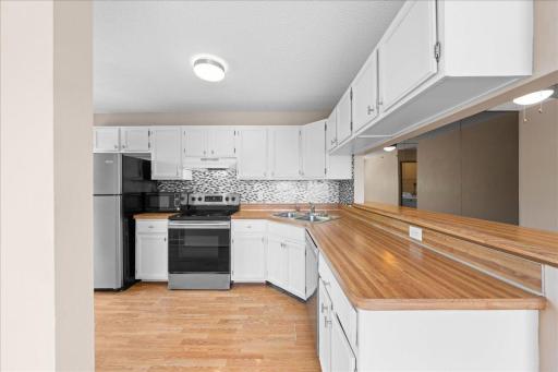 White cabinetry and backsplash makes the kitchen bright.