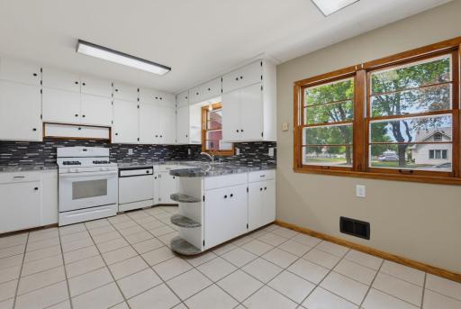 The eat-in kitchen features tile floors, white appliances, and plenty of cabinets for storage.