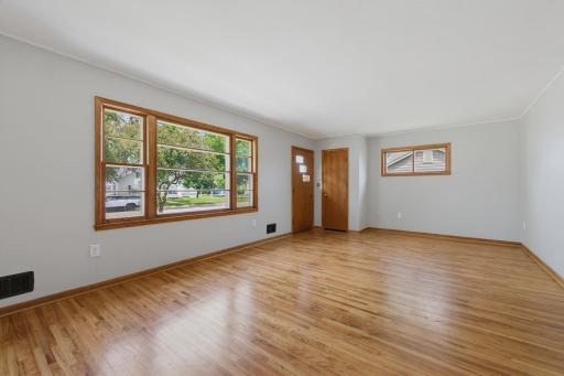 The living room features beautiful oak hardwood floors.