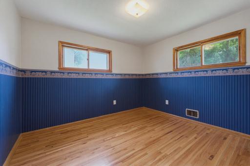 One of two main floor bedrooms. Oak hardwood floors are featured throughout the home including the bedrooms.