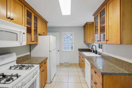 Updated kitchen offers birch cabinetry, quartz countertops and 18" tile floor.