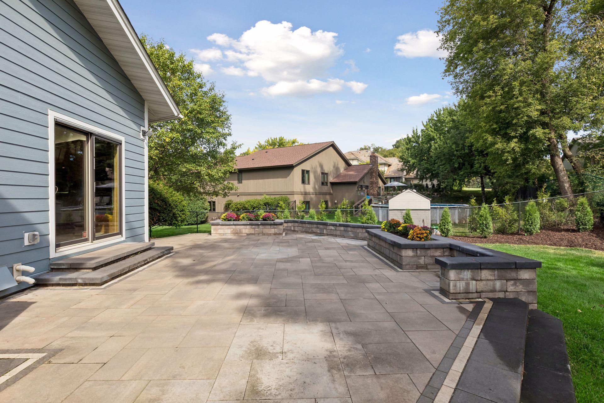 Expansive stone patio creates an ideal outdoor gathering space.