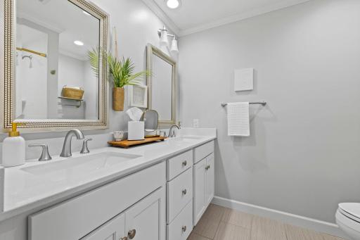 These bedrooms are conveniently located just steps away from a shared full bathroom featuring an updated dual vanity, toilet, and tub/shower combination, providing comfort and functionality for family or guests.