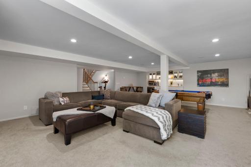 Another view of the open lower-level family and recreation spaces, showcasing their spacious and versatile layout.