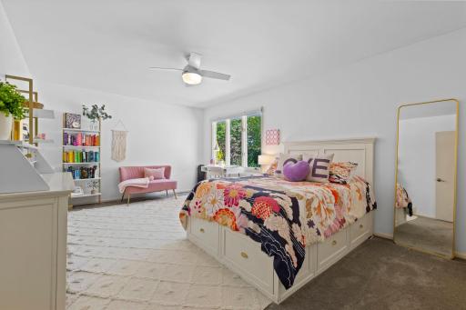 Bedroom two is generously sized and features ample closet space, a ceiling fan, and comfortable carpeting.