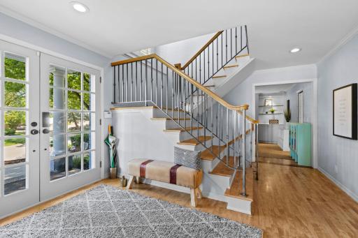 As you step through the double front doors, you are welcomed by an inviting foyer featuring stunning maple hardwood floors that flow throughout the main level.