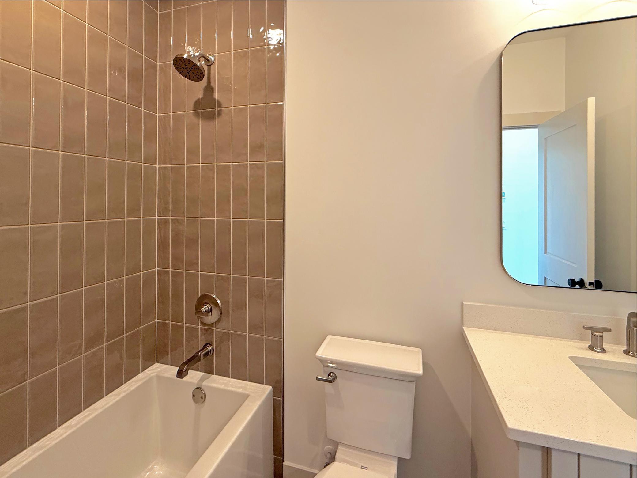 A beautifully tiled tub and shower surround provides the perfect space for guests or family, combining everyday functionality with elegant craftsmanship.