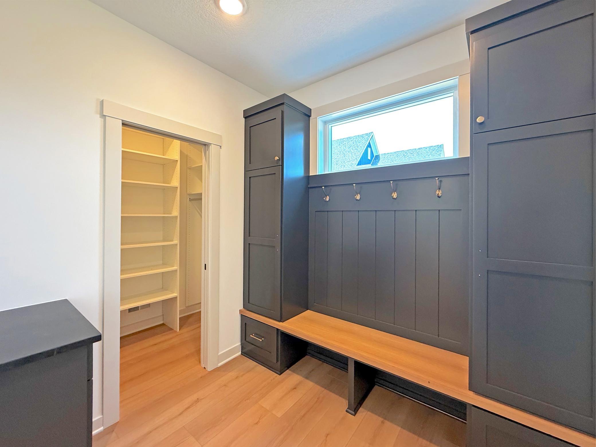Perfect for busy households and lake living, the mudroom features floor-to-ceiling storage lockers, a built-in bench, and an adjoining walk-in closet with shelving for exceptional storage.