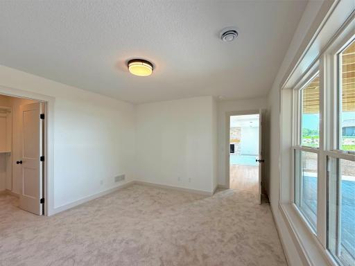 Offering both comfort and functionality, this spacious bedroom includes a generous walk-in closet with built-in shelving, providing exceptional storage and organization.