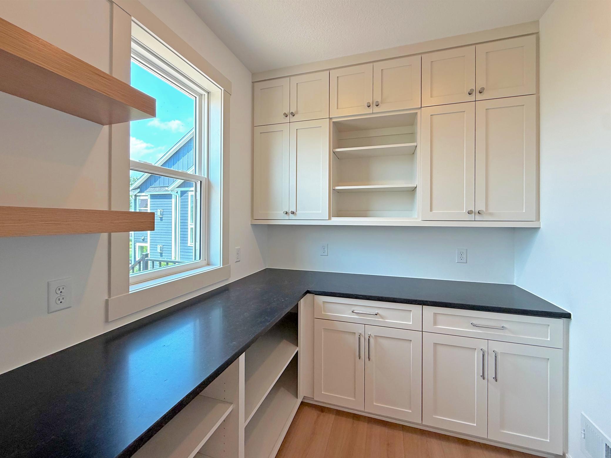 The thoughtfully designed walk-in pantry features custom cabinetry, abundant storage, and dedicated workspace, adding convenience and functionality to the heart of the home.