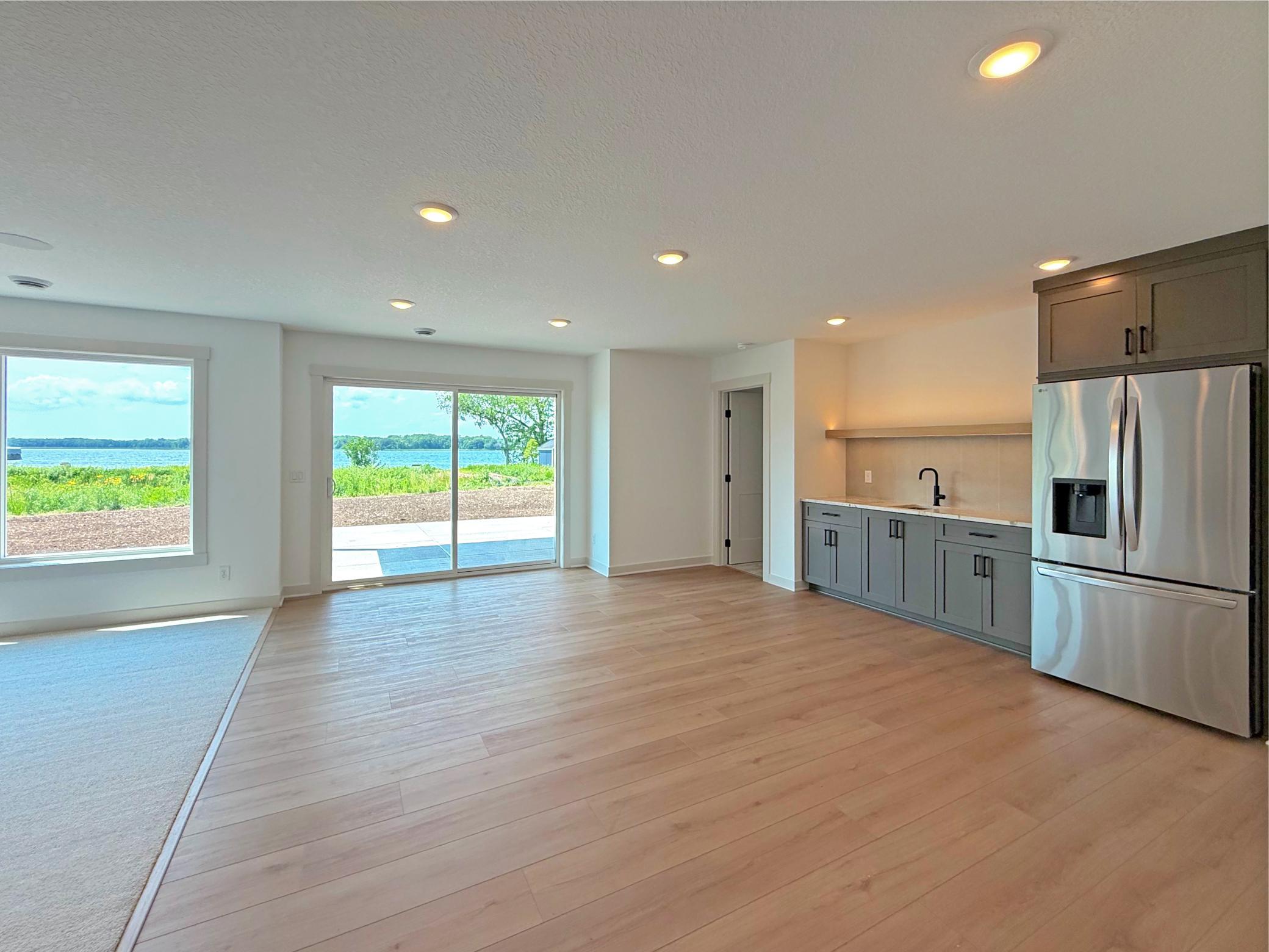 The walkout lower level is designed for entertaining, offering a spacious recreation area with easy access to the lakeside patio and beautiful views that bring the outdoors in.