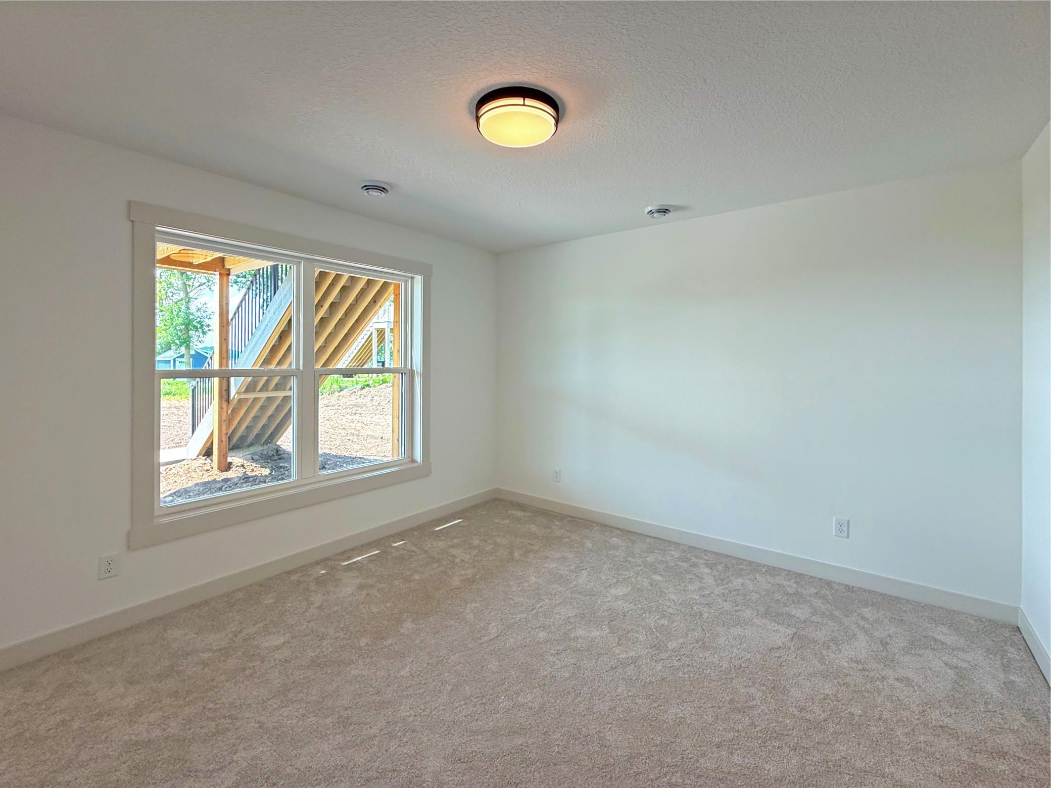 Designed with privacy in mind, this versatile lower-level bedroom offers a spacious layout with convenient access to the family room, making it ideal for guests or a private home office.