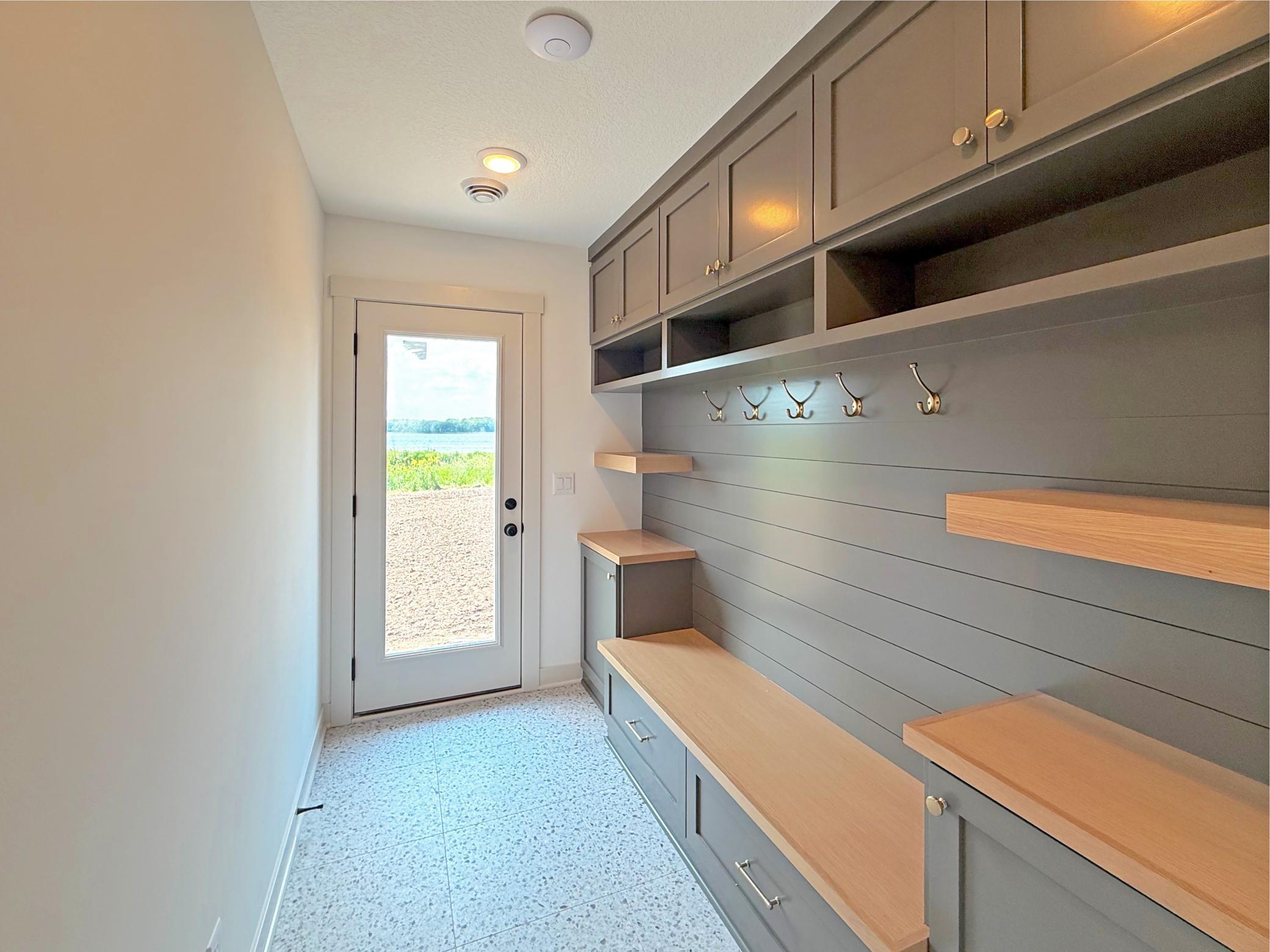 Designed with lake life in mind, the lower-level mudroom provides the perfect transition from the shoreline, featuring custom built-in lockers, bench seating, and abundant storage!