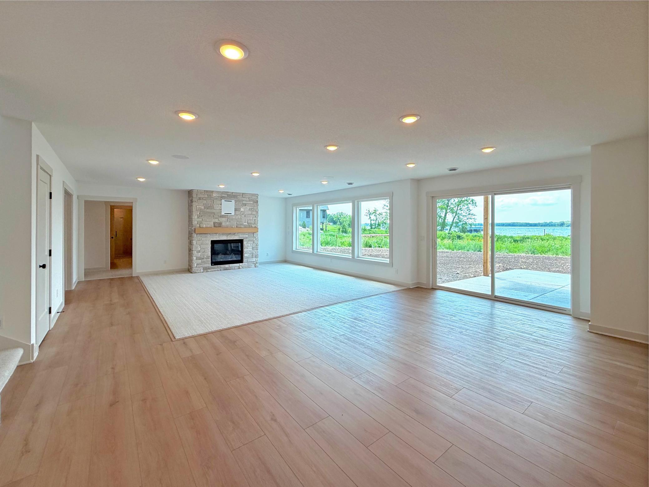 Large lakeside windows and a sliding glass door fill the lower level with natural light while providing easy access to the outdoor patio and picturesque lakefront setting.