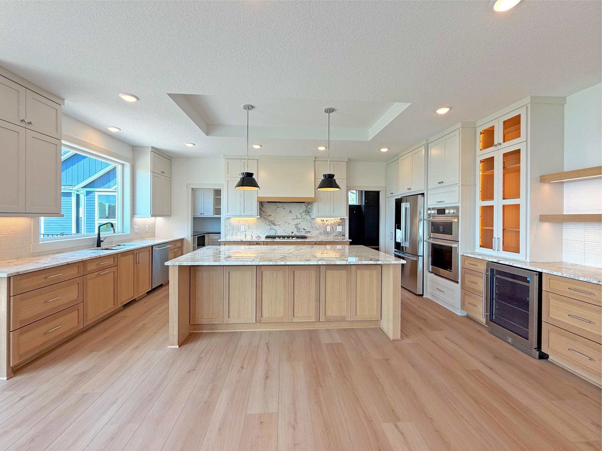 The chef's kitchen combines timeless style and everyday function with custom cabinetry, quartz countertops, premium stainless steel appliances, and a spacious center island perfect for gathering.