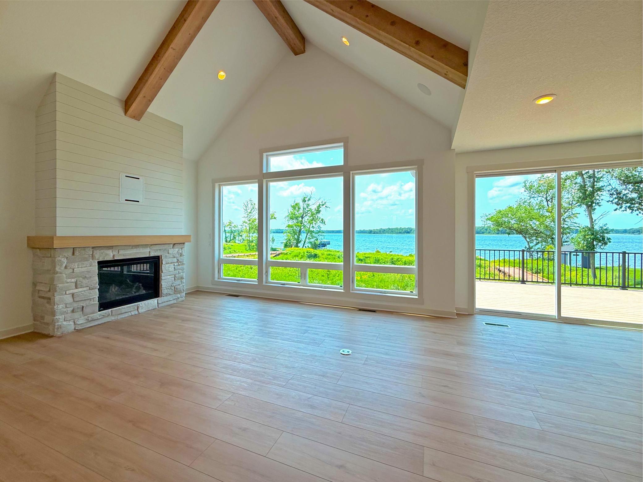 A dramatic wall of oversized windows showcases breathtaking lake views while filling the great room with an abundance of natural light, creating a bright and inviting space throughout the day.