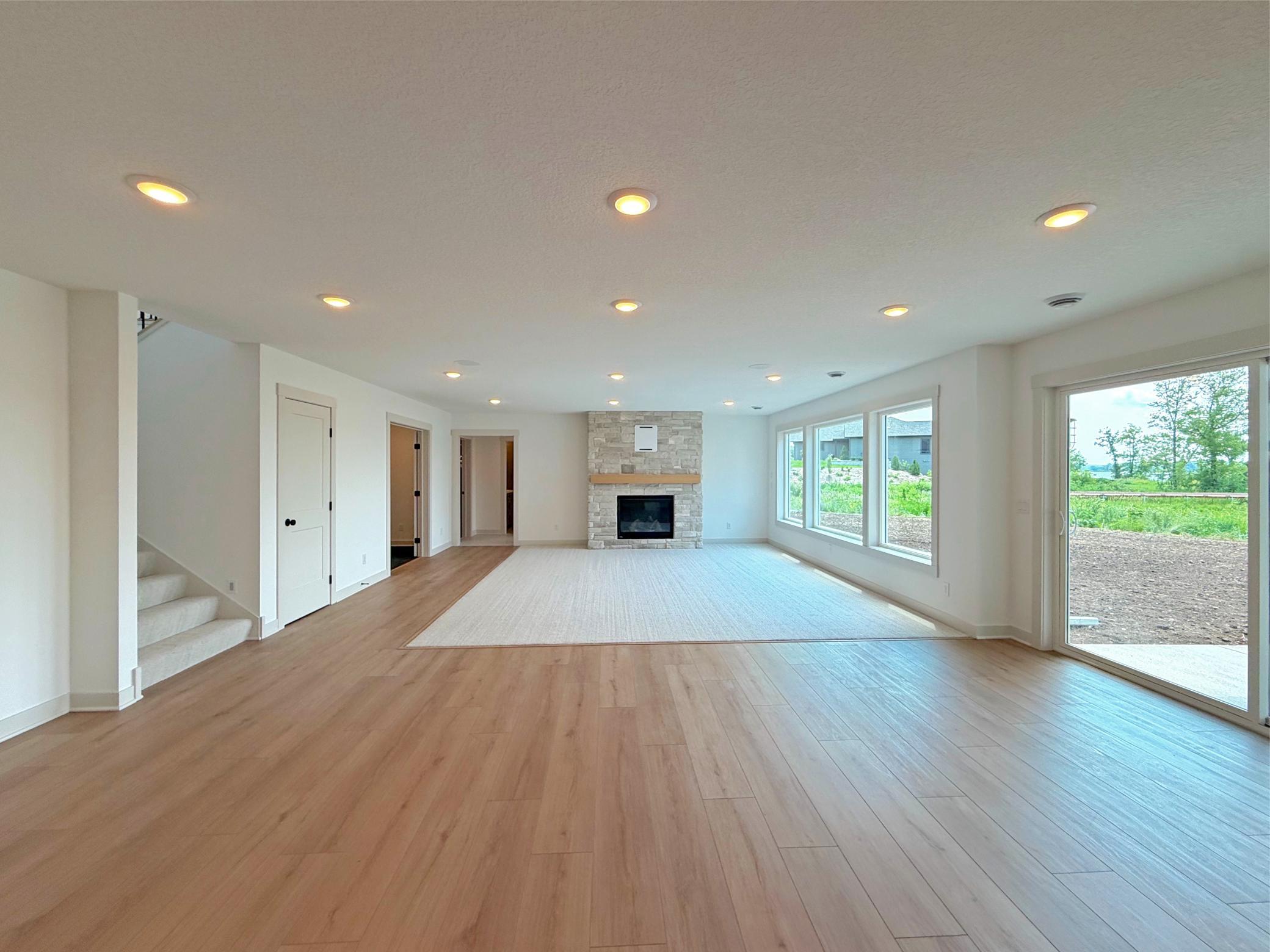 The expansive walkout family room offers endless possibilities for entertaining, featuring an open-concept design, abundant natural light, and seamless access to the lakeside patio.