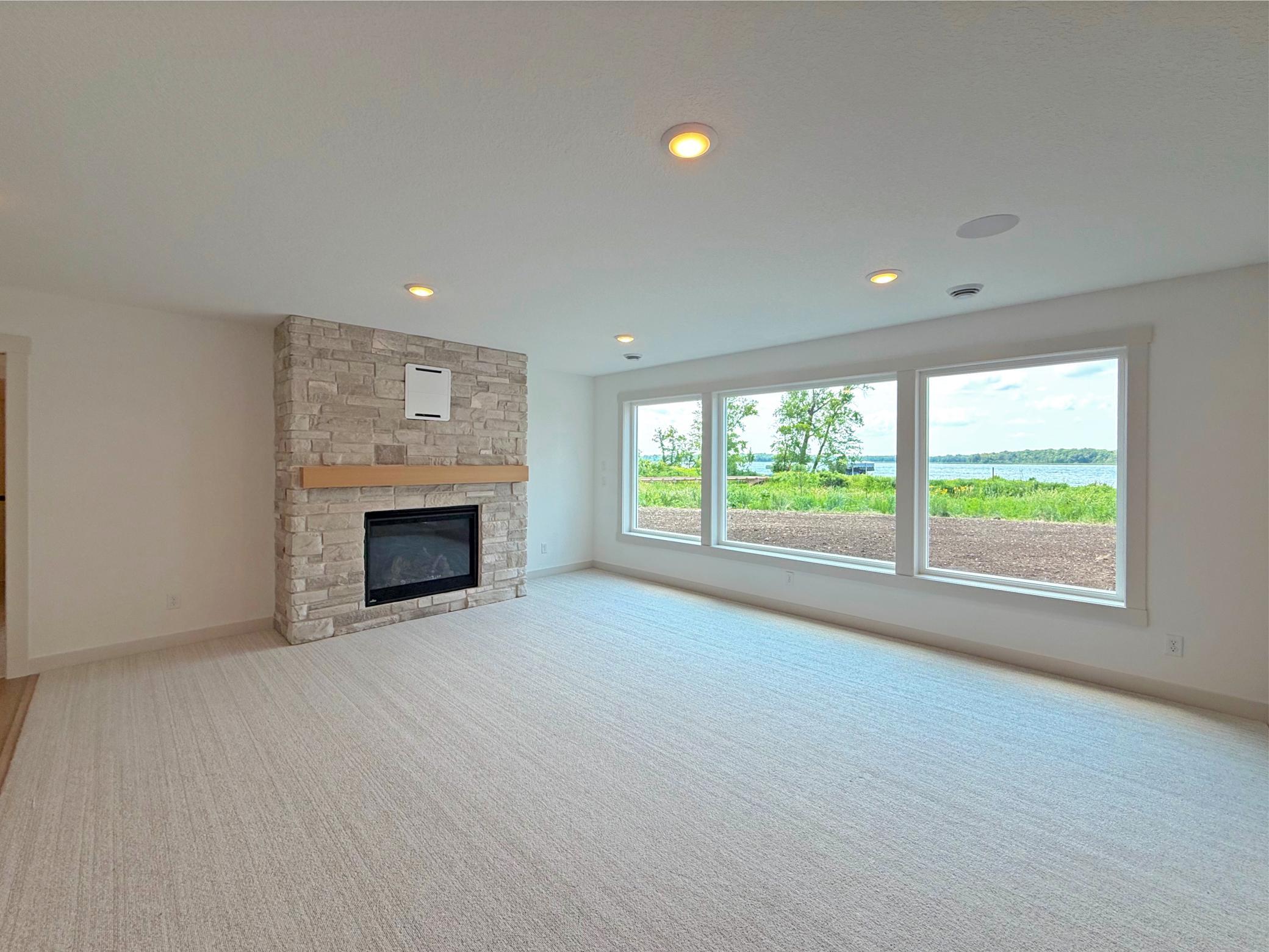 A beautiful floor-to-ceiling stone fireplace creates a warm focal point, making this spacious family room the perfect place to gather with family and friends year-round.