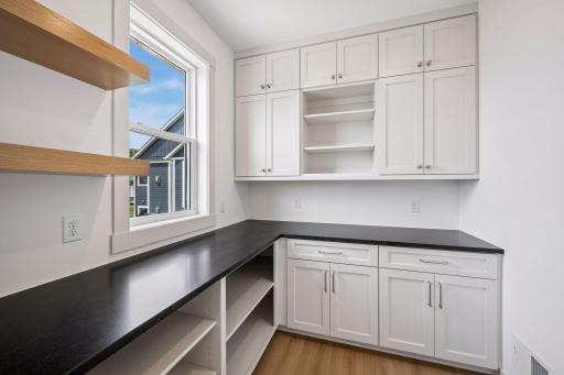 The thoughtfully designed walk-in pantry features custom cabinetry, abundant storage, and dedicated workspace, adding convenience and functionality to the heart of the home.