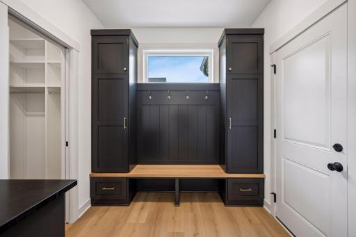 Perfect for busy households and lake living, the mudroom features floor-to-ceiling storage lockers, a built-in bench, and an adjoining walk-in closet with shelving for exceptional storage.