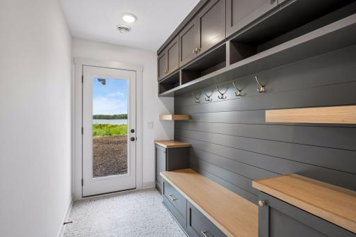 Designed with lake life in mind, the lower-level mudroom provides the perfect transition from the shoreline, featuring custom built-in lockers, bench seating, and abundant storage!