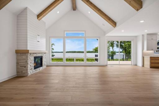 A dramatic wall of oversized windows showcases breathtaking lake views while filling the great room with an abundance of natural light, creating a bright and inviting space throughout the day.