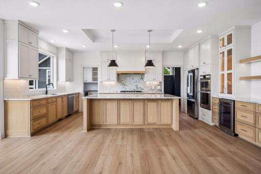 The chef's kitchen combines timeless style and everyday function with custom cabinetry, quartz countertops, premium stainless steel appliances, and a spacious center island perfect for gathering.