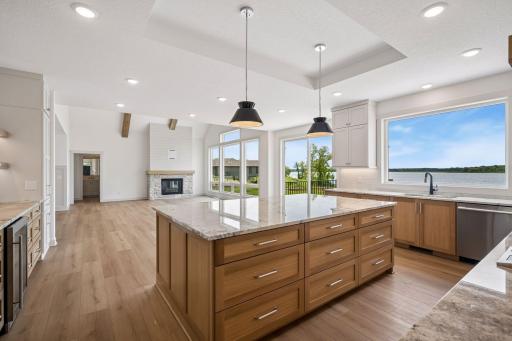 Expansive windows fill the kitchen with natural light while showcasing beautiful lake views. The open-concept design flows effortlessly into the dining area and great room.