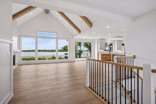 The breathtaking living room is designed to impress with soaring vaulted ceilings accented by exposed wood beams and a stunning floor-to-ceiling stone fireplace.