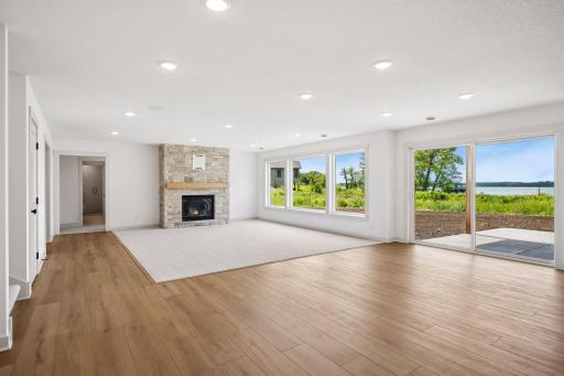 Large lakeside windows and a sliding glass door fill the lower level with natural light while providing easy access to the outdoor patio and picturesque lakefront setting.