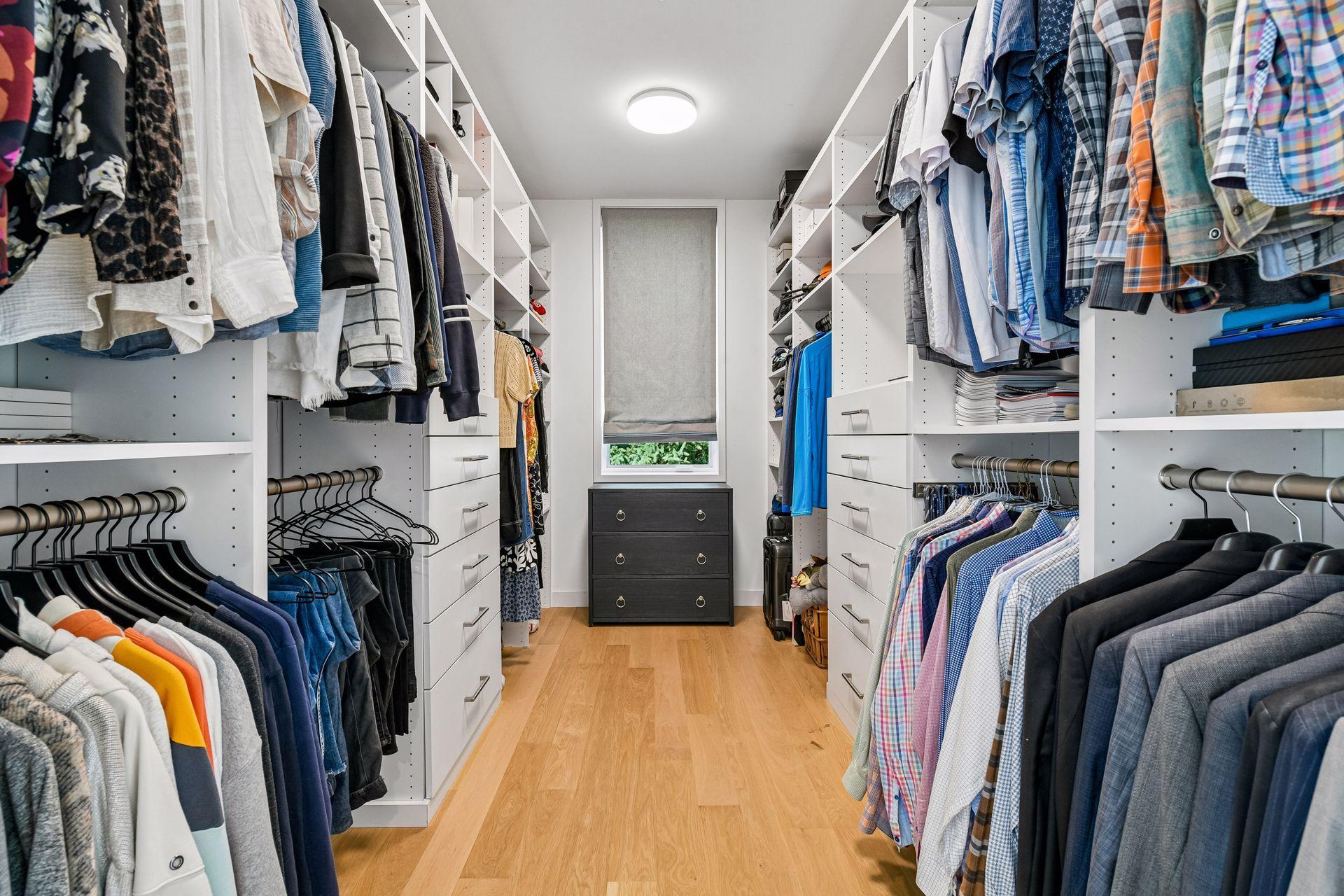 Custom closet organization includes a built-in ironing board and pull-out mirror