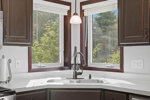 Kitchen features corner sink and two windows overlooking the backyard.
