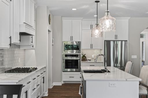 Kitchen features wall oven and stainless appliances.