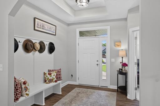 Welcoming front entry with built-in bench seating and a tray ceiling.