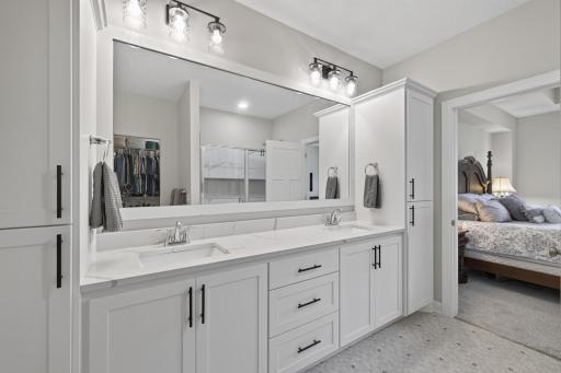 Primary bath with dual vanity and quartz surfaces.