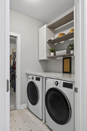 Pass-through laundry room connected to the primary suite.
