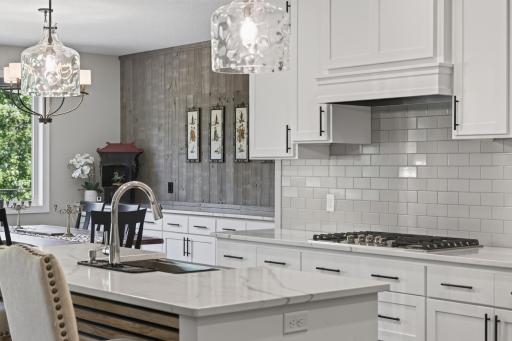 Kitchen and dining spaces flow together, highlighted by a custom accent wall and built-in serving area.