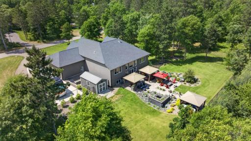 Outdoor kitchen, lounge gazebo, hot tub gazebo, and multiple gathering spaces connected by paver patios.