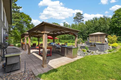 Three covered gazebo areas connected by extensive paver patios.