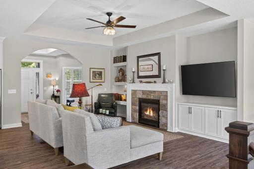 Living room with tray ceiling, built-in cabinetry, and views to the front entry.