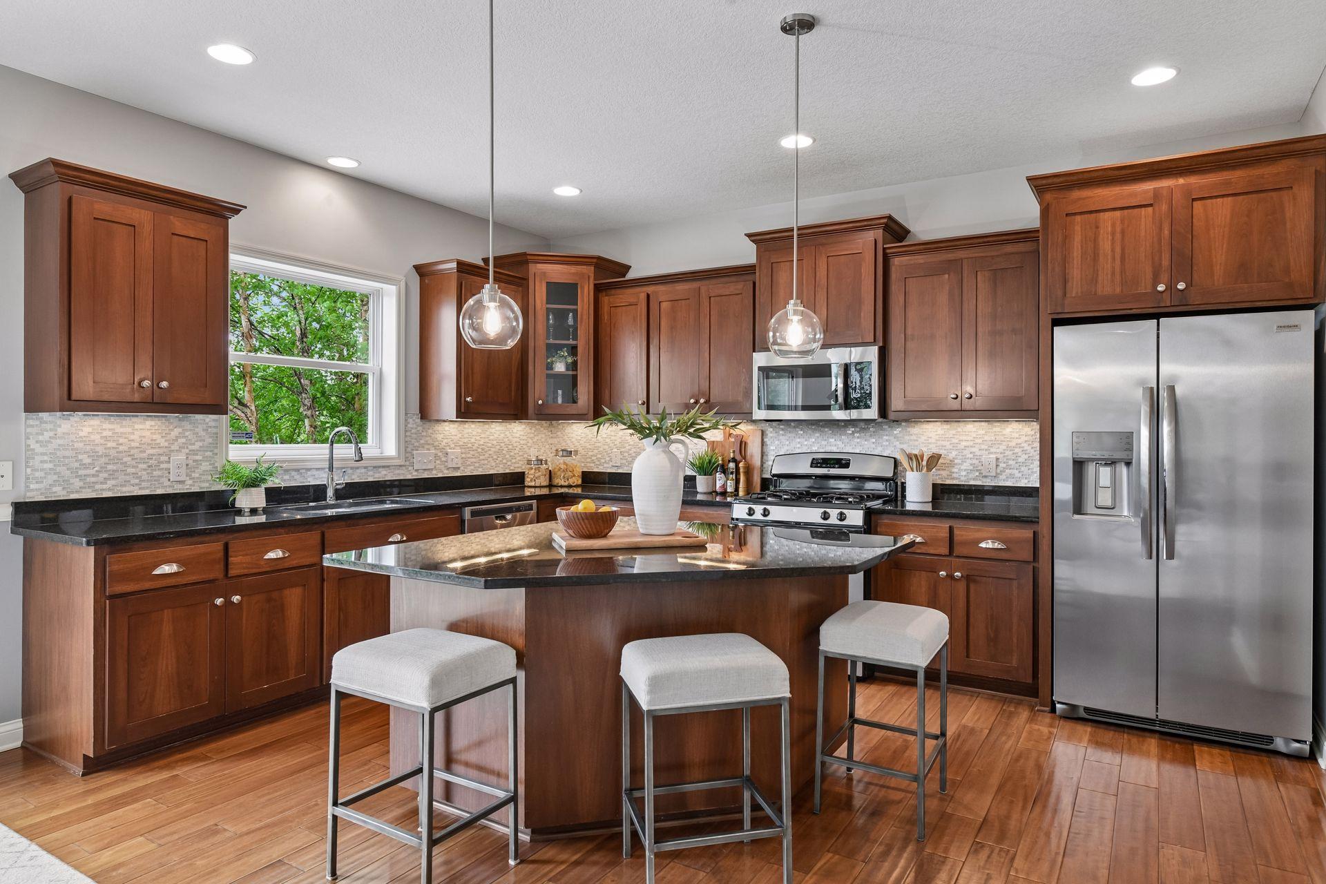 The kitchen serves as the heart of the home, featuring a large center island, abundant cabinetry, generous counter space, and walk-in pantry.