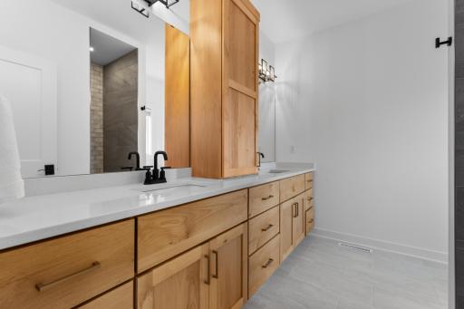 Primary bathroom with walk in shower and dual vanities.