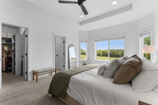 Large windows and tray ceiling create a bright, open feel.