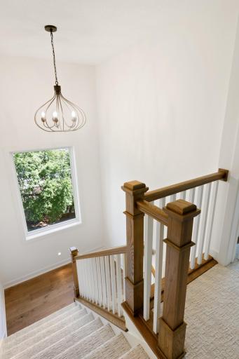 The stairwell feels light and airy with it's high ceilings and natural wood tones.