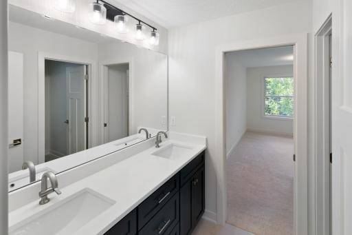 Jack-and-Jill bathroom with dual vanity and separate space for both the toilet and tub/shower.
