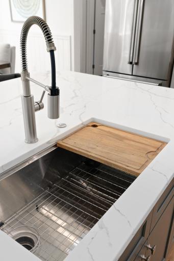 Single basin kitchen sink with built in cutting board.