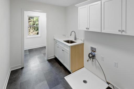 Upper level laundry room with utility sink and extra storage space.